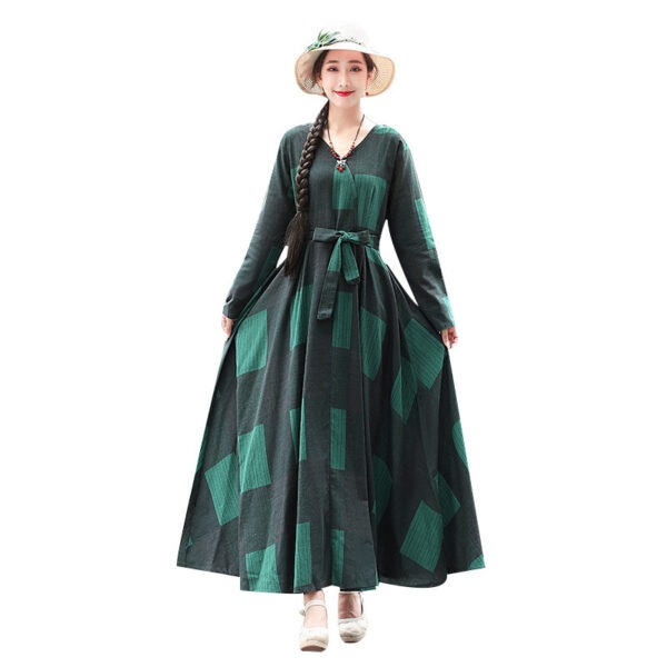 Woman wearing a long, flowing green dress with geometric patterns, styled with a wide-brimmed hat and braided hair, ideal for casual or outdoor occasions.