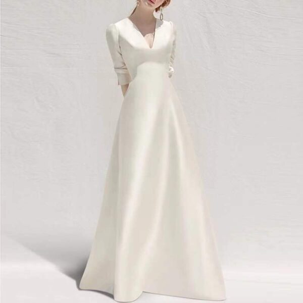 Elegant white long-sleeve dress with a deep V-neckline, perfect for formal occasions or weddings, showcased against a soft, neutral background.