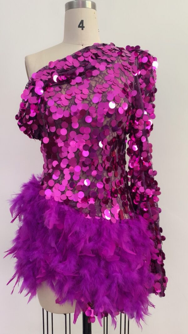 Vibrant purple sequin dress with one long sleeve and feathered hem, showcased on a dress form against a neutral background, perfect for evening wear or special occasions.