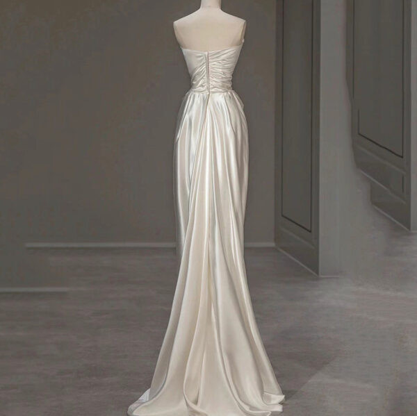 Elegant back view of a satin wedding dress featuring a strapless design and draped fabric, showcasing a fitted bodice and a flowing train, perfect for bridal occasions.