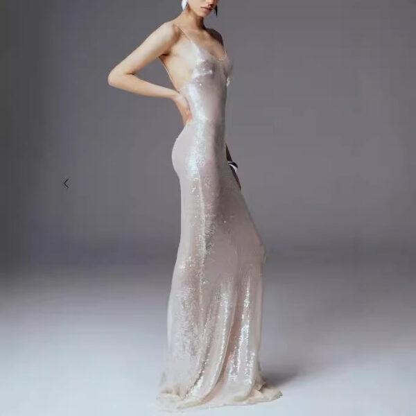 Elegant model showcasing a shimmering, fitted evening gown with thin straps, featuring a soft, iridescent fabric that accentuates the silhouette against a neutral background.