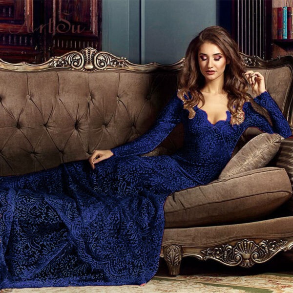 Elegant woman in a blue lace evening gown lounging on a vintage sofa, showcasing a sophisticated fashion style. The setting features rich textures and a classic decor, highlighting the gown's intricate design and the model's graceful pose.