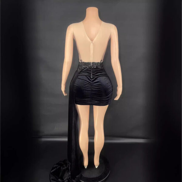 Back view of a stylish black mini dress featuring a plunging back design and elegant detailing at the waist, displayed on a mannequin against a dark background.