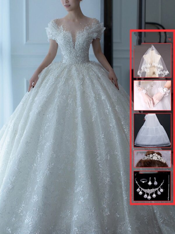 Elegant bridal gown featuring intricate lace details and a voluminous skirt, complemented by accessories including a veil, gloves, and sparkling jewelry. Ideal for weddings and formal occasions.