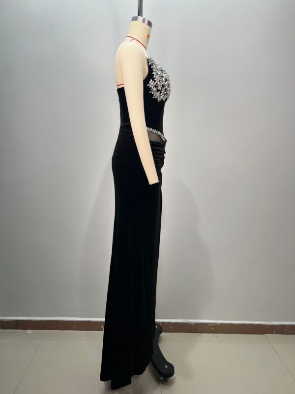 Elegant black evening gown displayed on a mannequin, featuring intricate beading on the bodice and a flowing skirt. The dress showcases a fitted silhouette, perfect for formal occasions or special events.