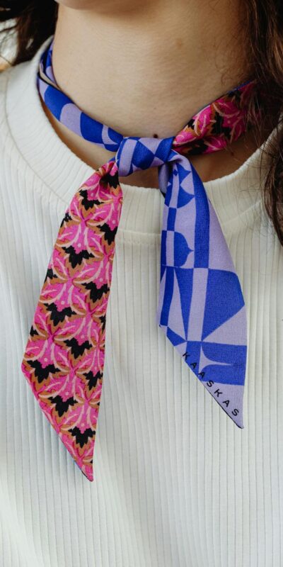 Close-up of a woman wearing a colorful patterned scarf, showcasing fashion elegance.