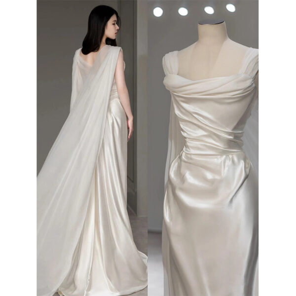 Elegant satin evening gown featuring a draped design with a flowing cape. The dress showcases a sophisticated off-shoulder neckline and intricate ruching details, highlighting a graceful silhouette. Ideal for formal occasions and special events.