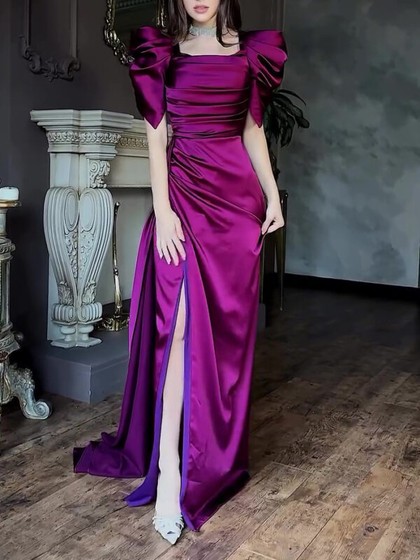 Elegant woman wearing a luxurious purple satin evening gown with puff sleeves and a thigh-high slit, showcasing a chic, sophisticated style in a beautifully decorated interior.